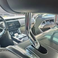 Interior view of a modern car showing the drivers side dashboard, steering wheel, and open door with sleek design