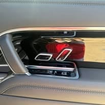 Car door panel showing interior with red and black upholstery and control buttons